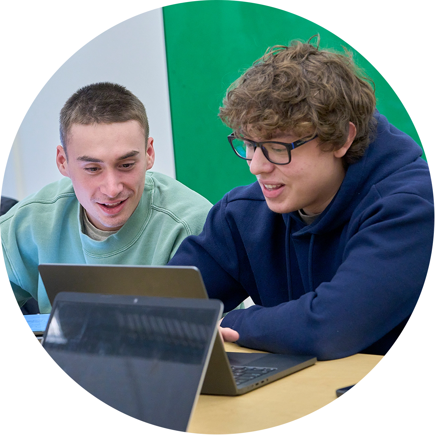Two College of Business Students focusing on their classwork while attending a lecture