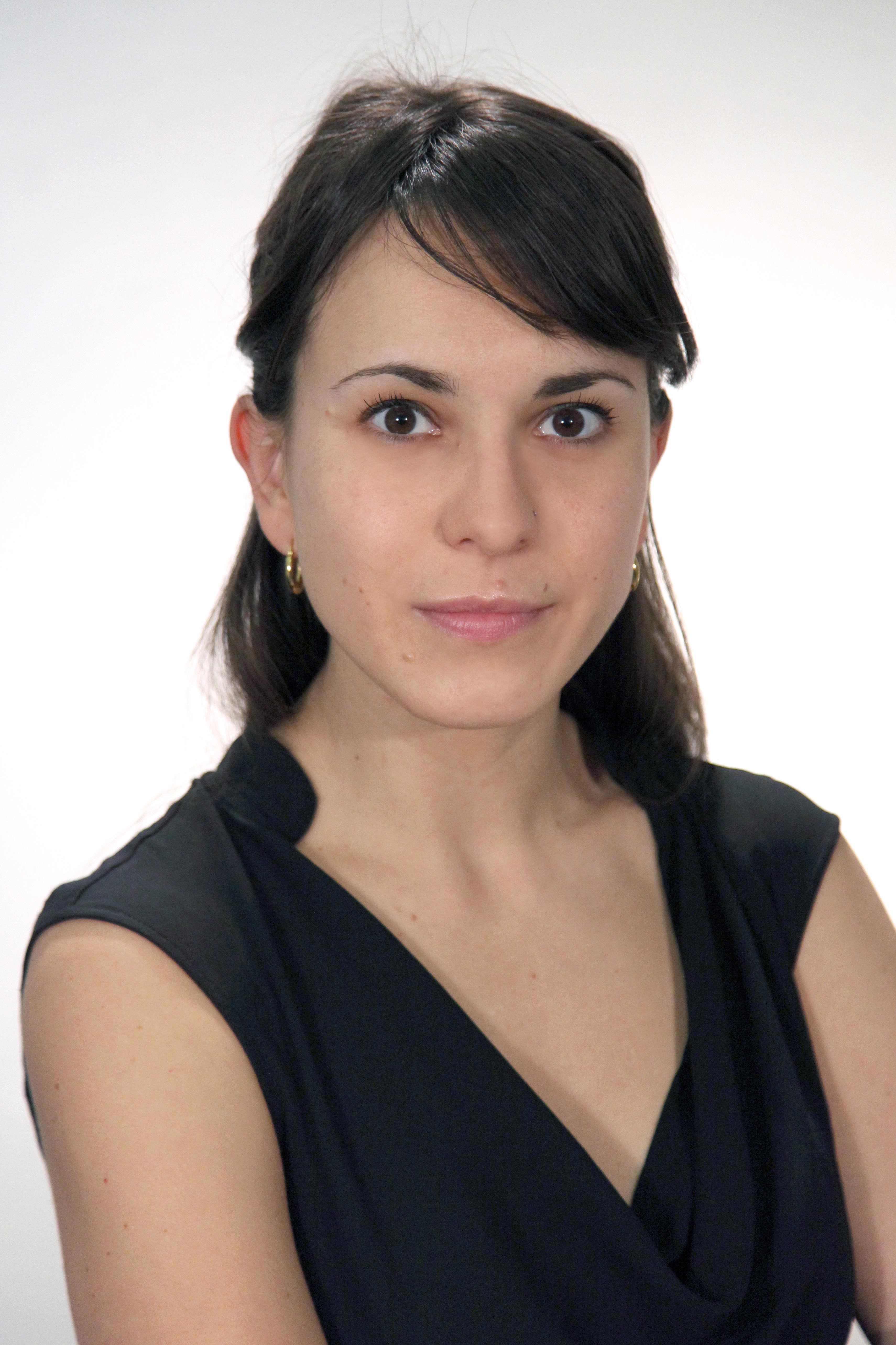 Black and white portrait of a person wearing a sleeveless top, looking directly at the camera.