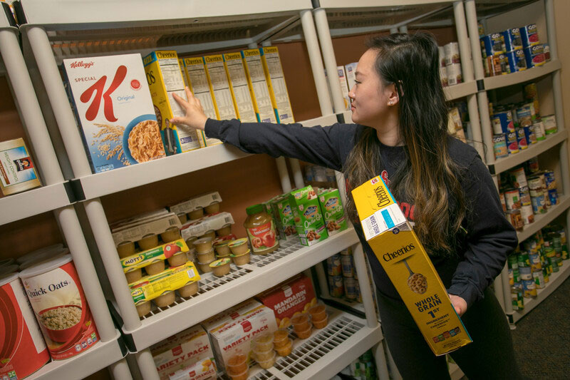 Seawolves Pantry Shelves Student stocking shelves with grocery items