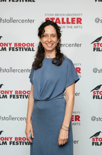 Woman in blue dress in front of film festival logos.