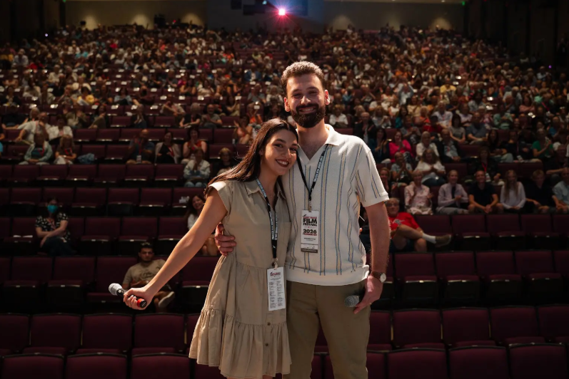 Two people standing in front of audience