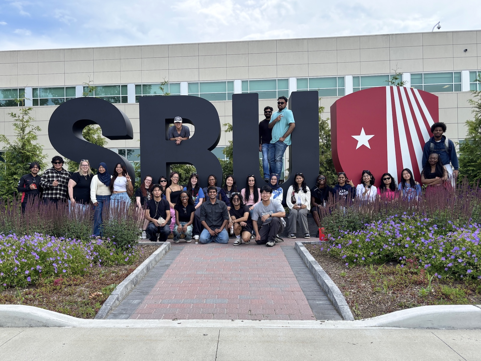 The 2026 PCS ambassador team gathered around Stony Brook's giant SBU letter and logo sign